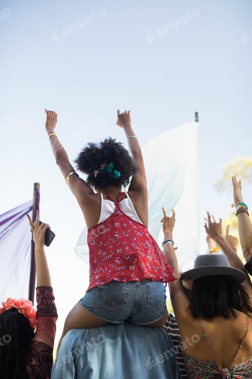 Preview: Friends enjoying against sky at music festival