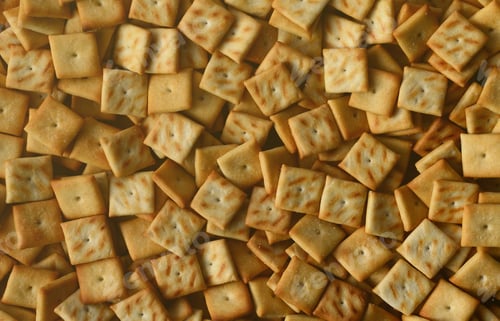 Preview: A lot of small cookies are square shaped. A pattern of a yellow salt cracker. Background