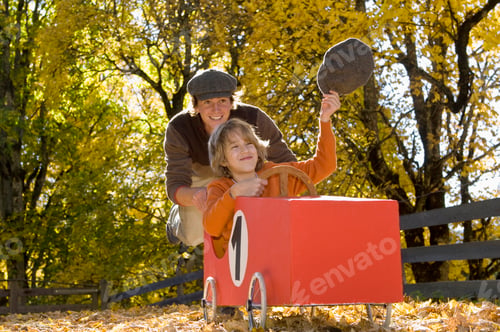 Preview: Austria, Salzburger Land, Man pushing soapbox car, boy (12-13) waving cap