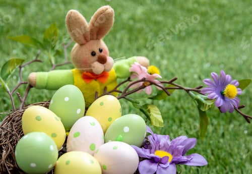 Preview: Happy Easter. Colorful eggs in a nest on green grass, close up view