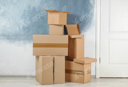 Preview: Pile of cardboard boxes near color wall indoors