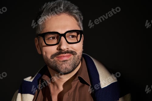 Preview: Stylish man in glasses showcases elegant outfit in a trendy studio setting