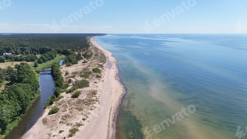 Preview: Aerial view of a serene coastline with lush greenery and clear blue waters under a bright sky.