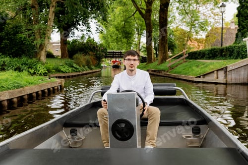 Preview: Portrait of a handsome young guy steering a boat.