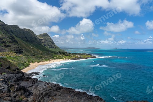 Preview: Tropical coastline with turquoise waters and green mountains.