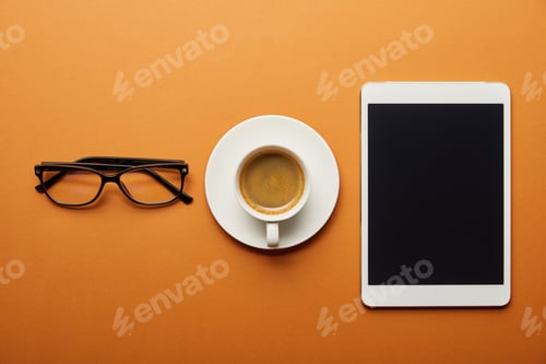 Preview: top view of digital tablet with blank screen near cup with drink and glasses on orange