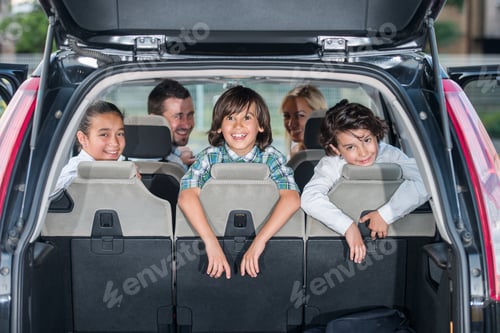 Preview: Happy Smiling Family In The Car Looking Backwards Through Open Trunk