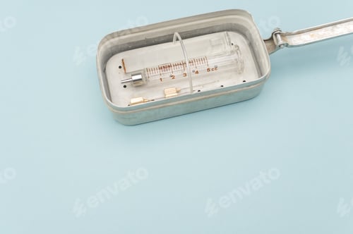 Preview: isolated sterilized glass injection syringe in a box on a blue background