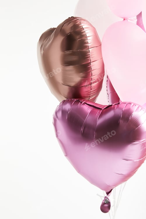 Vista previa: heart-shaped pink and golden festive air balloons isolated on white