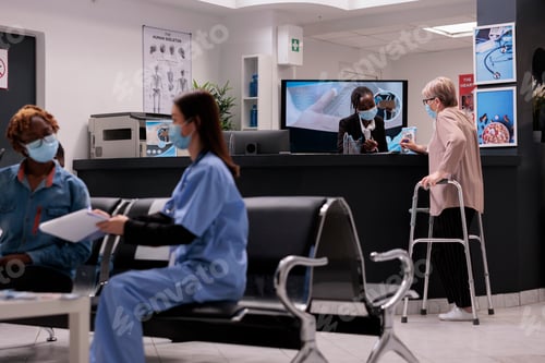 Preview: Elderly caucasian woman using walker signing at medical clinic