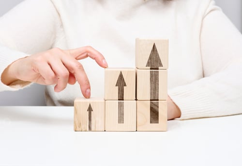Preview: Stack of wooden cubes, person's fingers go up the steps. Business growth concept, goal achievement