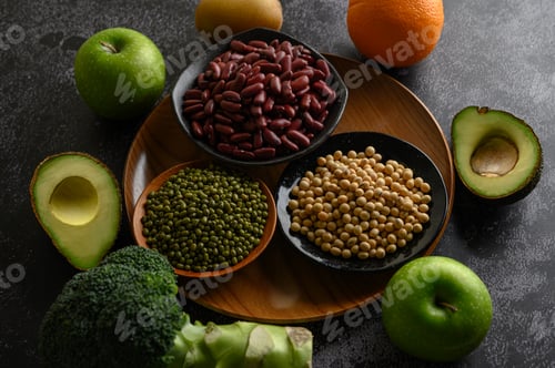 Preview: legumes and fruit on a black cement floor background.