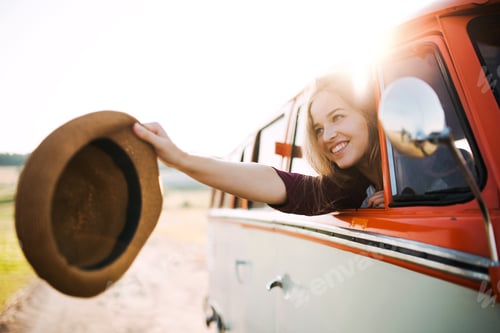 Preview: A young girl looking out of a car on a roadtrip through countryside.