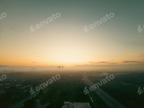 Preview: Aerial view of the golden sunrise near the highway in Malaysia with misty morning fog.