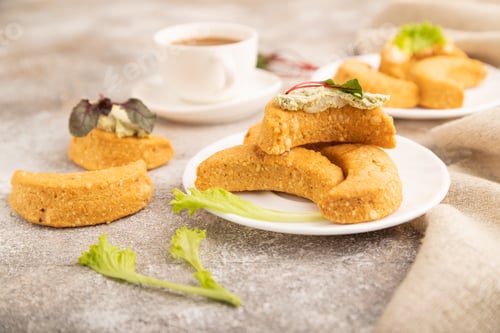 Preview: Homemade salted crescent-shaped cheese cookies, cup of coffee on brown concrete background
