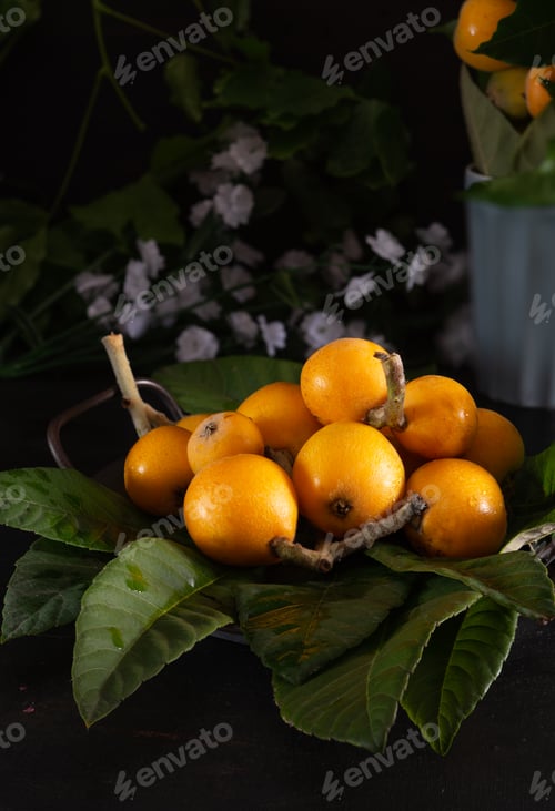 Preview: medlars freshly picked with leaves on wooden background