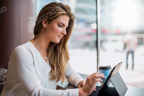 Preview: Young businesswoman in a cafe using tablet