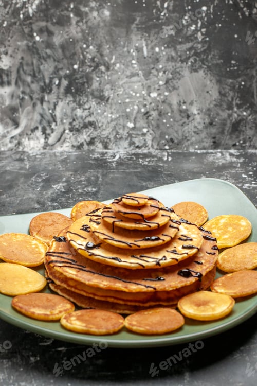 Preview: Close up view of pancake decoration on a green plate on gray background