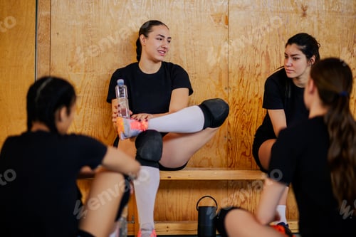 Preview: Diverse young female volleyball players sitting on a bench and relaxing