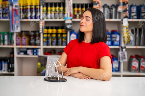 Preview: Young woman finding stress relief, eyes closed, beside a newton's cradle at her desk