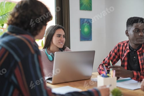 Preview: Young multiracial students learning together at home using books and computer laptop