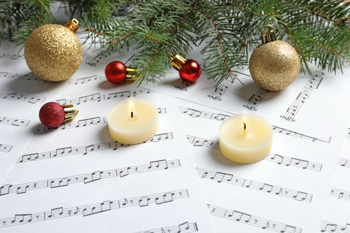 Preview: Composition with Christmas decorations and candles on music sheets