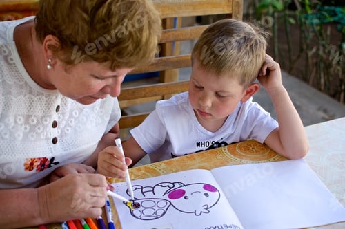 Preview: Young boy draws with the senior woman