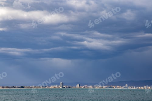 Preview: View of the night city with lights surrounded by the Black Sea and wrapped in clouds in the evening