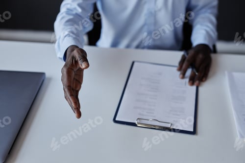 Preview: Black businessman stretching hand to camera for handshake at job interview