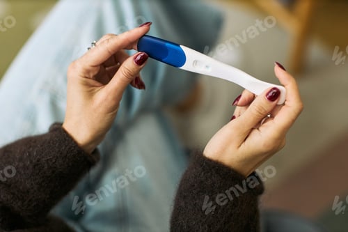 Preview: Caucasian Woman Holding Digital Pregnancy Test in Home Setting