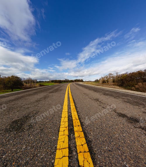 Preview: Wide-angle view of empty rural road with yellow lines.