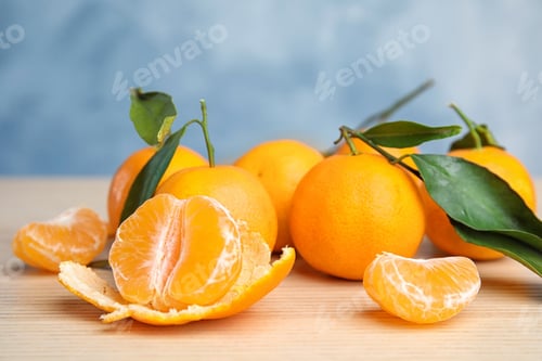 Vorschau: Frische reife Mandarinen mit grünen Blättern auf dem Tisch