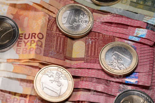 Preview: Stack of ten Euro banknotes, Euro coins on red 10 Euro bills