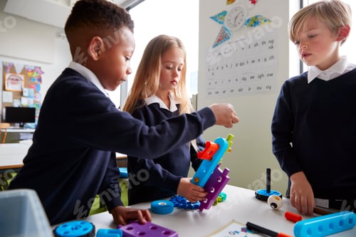 Preview: Three primary school children working together with toy construction blocks in a classroom