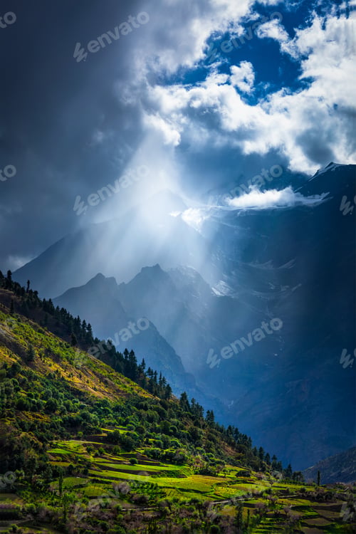 Preview: Sun rays through clouds in Himalayan valley in Himalayas