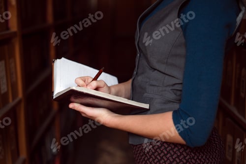 Preview: Close up of female hands making notes in notebook