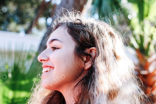 Preview: Young pretty girl with long curly hair outdoors