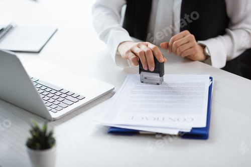 Preview: partial view of businesswoman stamping contract at workplace