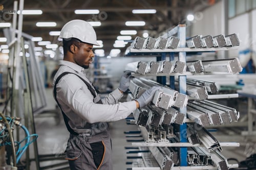 Preview: Factory worker checking aluminum profiles for windows and doors production