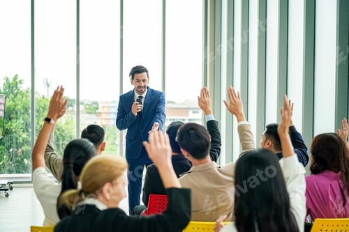 Preview: Raised up hands of large group in seminar class room to agree with speaker at conference seminar
