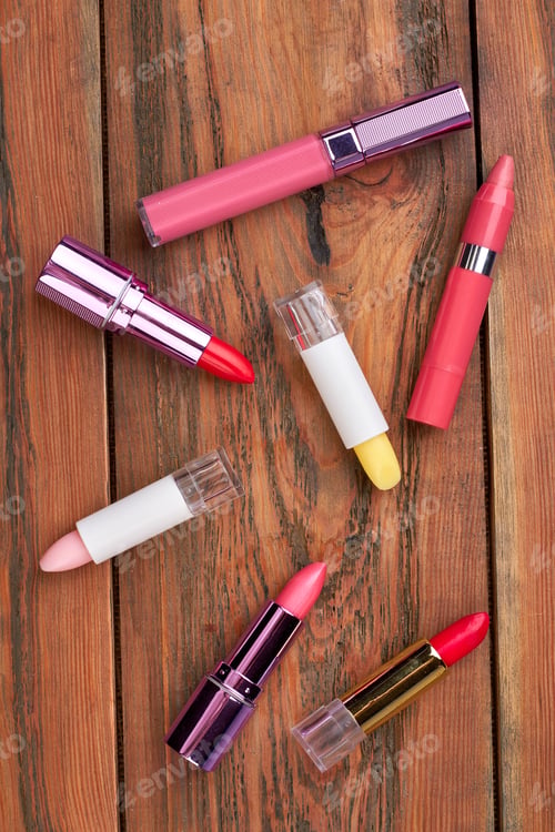 Preview: Colorful lipsticks on brown wooden table.