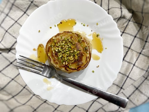 Preview: Stack of Pancakes Topped with Syrup and Pistachios
