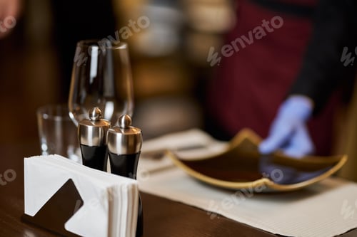 Preview: Rstaurant table with glasses and plates being set-up