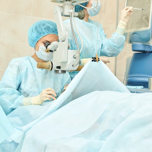 Preview: Female surgeon caucasian mature performing microsurgery with advanced optical