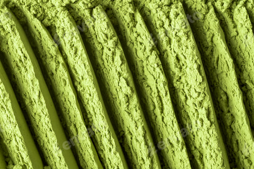 Preview: Close-up of green matcha powder shaped into rhythmic grooves with rich textured surface