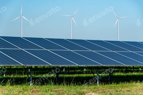 Preview: Solar panels and wind turbines on open field, with nice blue sky, white clouds and the reflection of
