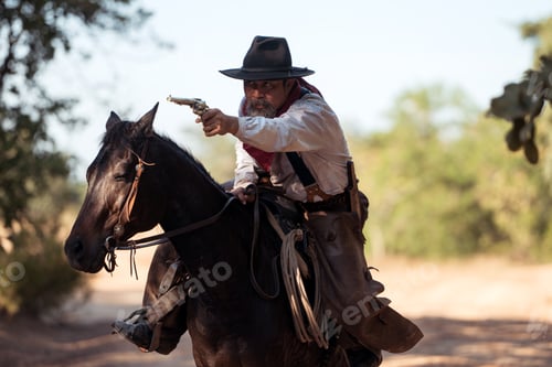 Preview: A cowboy on a rearing horse holding a revolver, capturing a classic and dramatic