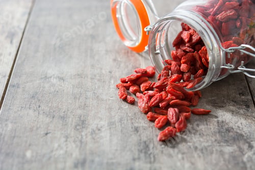 Preview: Delicious Goji Berries Spilling from Jar on Wood