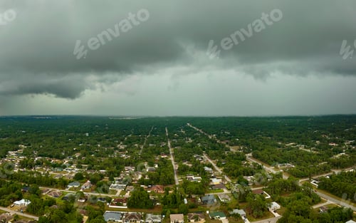 Preview: Dark stormy clouds forming on gloomy sky before heavy rainfall over suburban town area