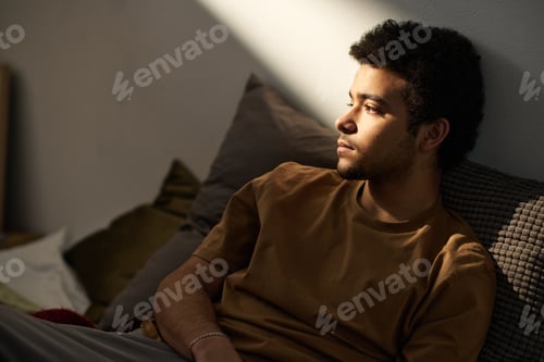Preview: Sad teenage boy sitting alone in his room